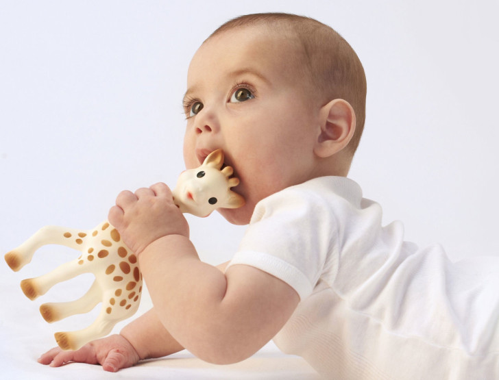 Ребенок пробует игрушку Ребенок пробует игрушку